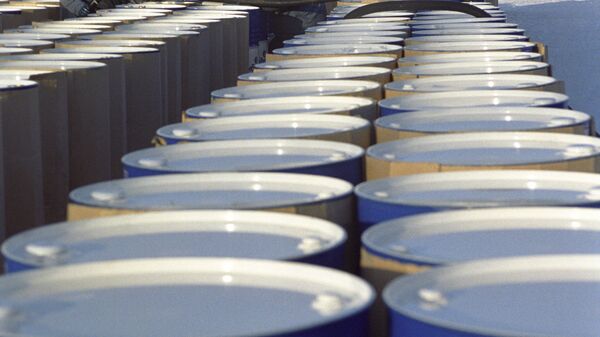 Рабочие заливают топливное масло в нефтяные бочки